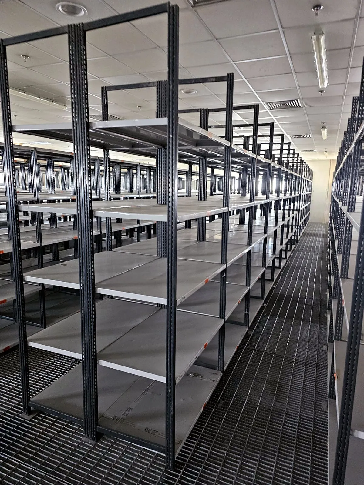 Grey slotted angle shelving racks in a UAE store room